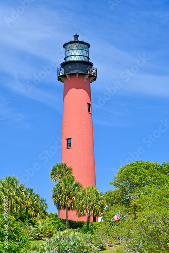 Historic red brick Jupiter lighthouse against blue skies at Jupiter Inlet, Florida