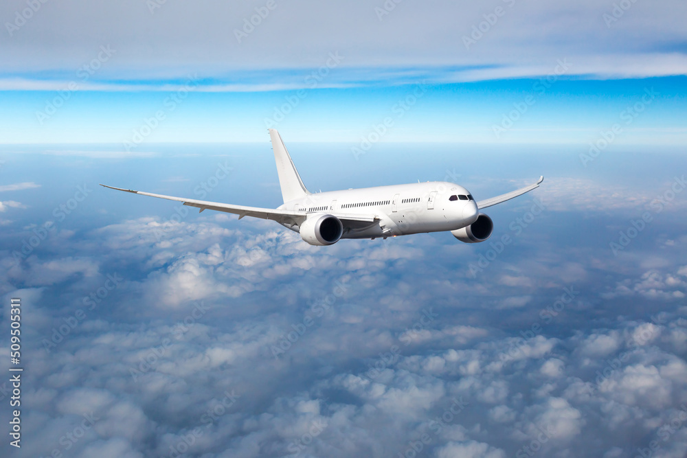 Fototapeta premium Passenger plane in flight. Aircraft fly high in the sky above the clouds. Front view of aircraft.