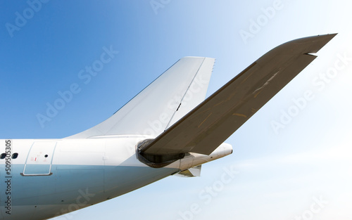 Tail of a passenger plane close-up. Blue sky in the background.