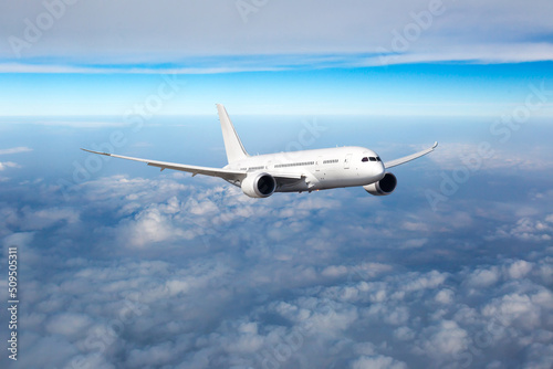 Passenger plane in flight. Aircraft fly high in the sky above the clouds. Front view of aircraft.