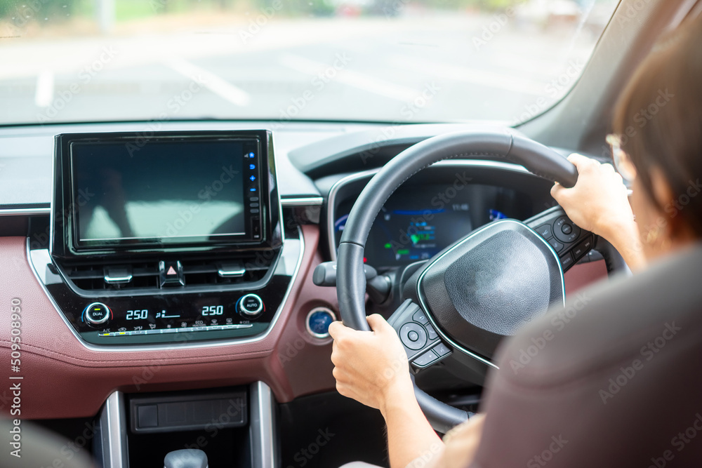 woman driver driving a car on the road, hand controlling steering wheel in electric modern automobile. Journey, trip and safety Transportation concepts woman driver driving a car on the road, hand controlling steering wheel in electric modern automobile. Journey, trip and safety Transportation concepts