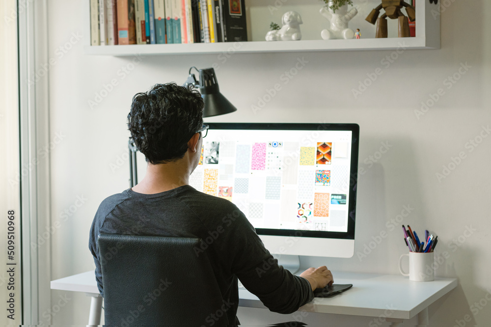 Latin man working remotely. Graphic design professional working from home.  Creative making illustrative designs on his computer. Home office with  minimalist design. Stock Photo | Adobe Stock