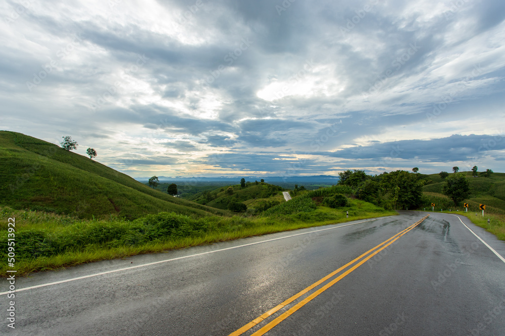 countryside road passing through the green forrest and mountain