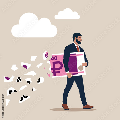 Businessman holding big ruble banknote money while loss, crumble and reduce in value. Lose money ruble investment in financial crisis, profit and loss in business or deflation and inflation concept.