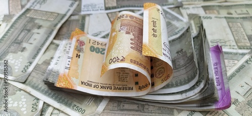 Bunch of different coloured indian currency bank notes of 200, 2000 and 500 scattered on table. Close up macro flat lay areal top view. Financial, savings, wealth and investment concept background.
