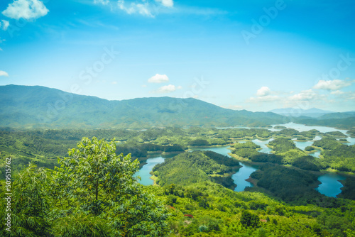 Morning at the Ta Dung lake or Dong Nai 3 lake with green hills and mountains. Travel and landscape concept. Travel concept. © CravenA