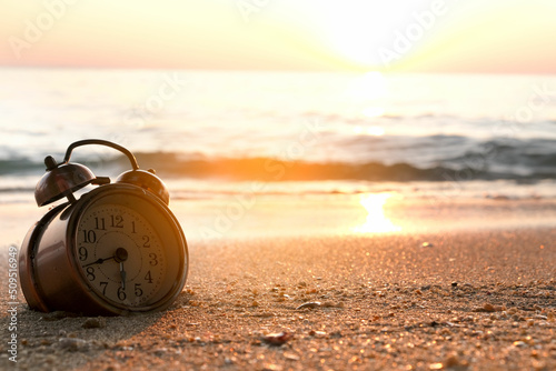 Morning of a new day, alarm clock on the beach sunlight in morning. Health concept.