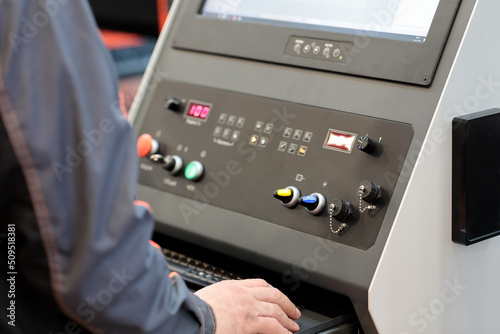 worker controls metalworking CNC machine