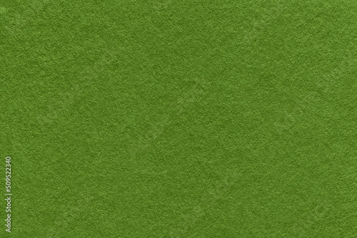 Texture of dark green and olive colors paper background, macro. Structure of dense lime craft cardboard.