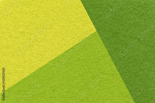 Texture of craft green, olive and yellow colors paper background, macro. Structure of vintage dense craft cardboard