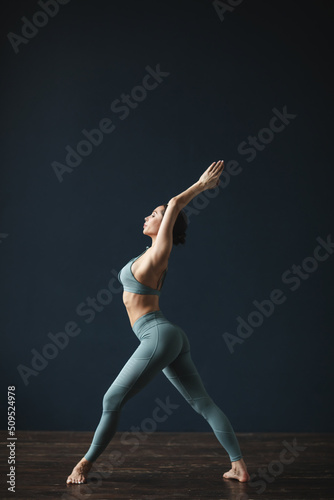 Fitness woman posing in the studio on a dark background.