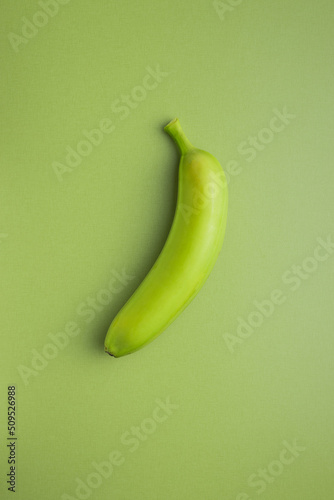 Unripe green banana on green table.