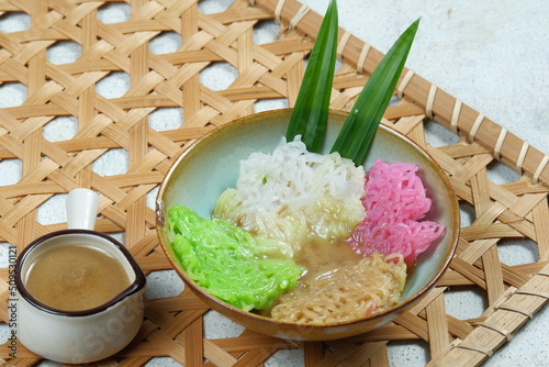 Kue Putu Mayang or petulo is traditional Indonesian snack made from rice flour strands curled up into a ball, served with coconut milk and palm sugar photo