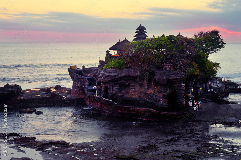 Beautiful balinese landscape. Ancient hinduism temple Tanah lot on the rock against sunset sky. Bali Island, Indonesia.