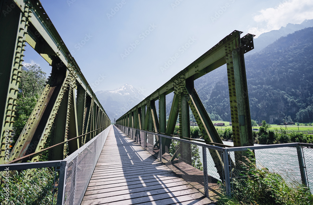 Hiking on the Swiss Alp Mountains. Metal girder bridge with pathway.