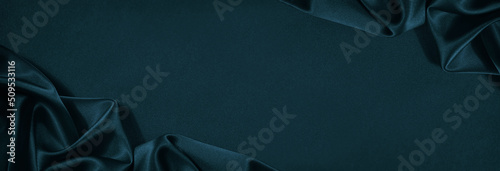 Beautiful dark blue green silk satin background. Soft folds on shiny fabric. Luxury background with copy space for design. Web banner. Wide. Flat lay, top view table. Christmas, Valentine. photo