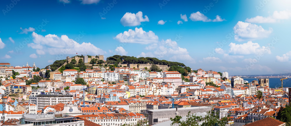 Panoramic view of the skyline of Lisbon, Portugal, with Sao Jorge Castle and the red roofes of the Alfama district until the River Tagus on a sunny day