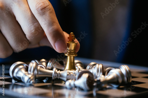 Closeup shot of hands of unrecognizable businessman holding two kings and making them fight over chess board
