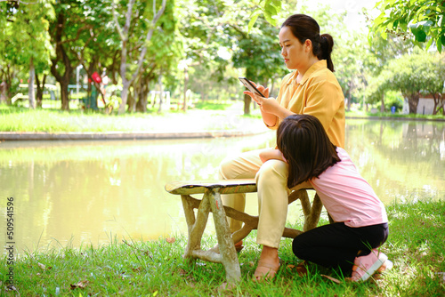 Photo background of Asian woman relaxing playing on the phone by the water showing her face in the field.