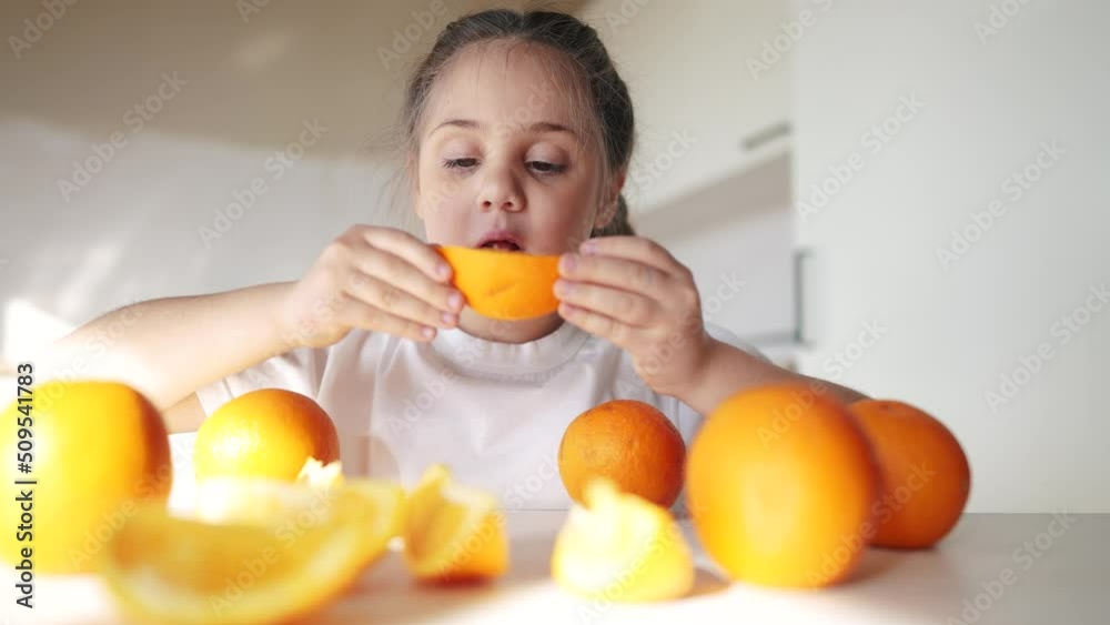 girl child eating oranges. happy family fruit healthy food kid concept. little girl daughter eating oranges at the table in dream the kitchen indoors. juicy fruits oranges are for a healthy diet girl child eating oranges. happy family fruit healthy food kid concept. little girl daughter eating oranges at the table in dream the kitchen indoors. juicy fruits oranges are for a healthy diet