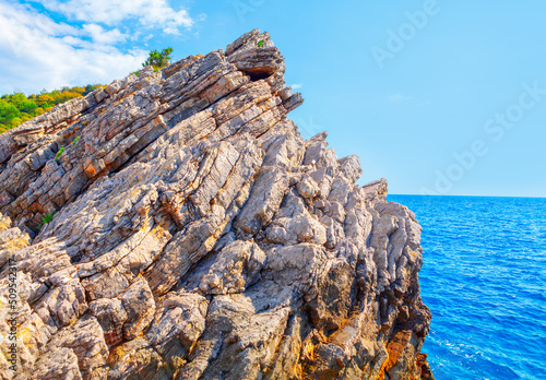 Sedimentary rock in the sea . Rocky isle scenery 