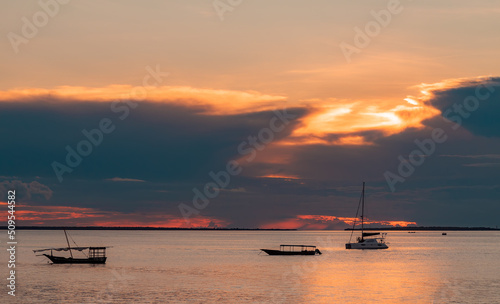 Fishing ship and boats in water of Indian ocean on a scenic sunset. Zanzibar, Tanzania