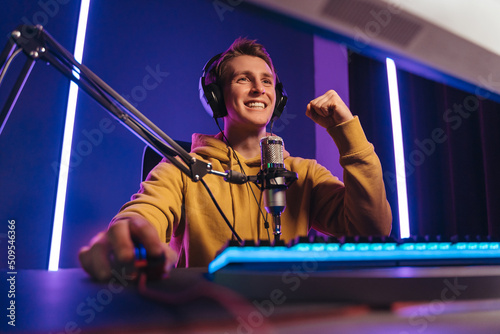 Pro esport gamer feel excited while playing in online cyber sport play, he won game and cheer with hands gesture, smiling, feel glad and happy with his victory. Computer dependence, games obsession photo