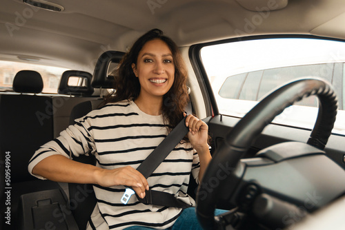 Arabic Female Driver Putting On Seat Belt Sitting In Car