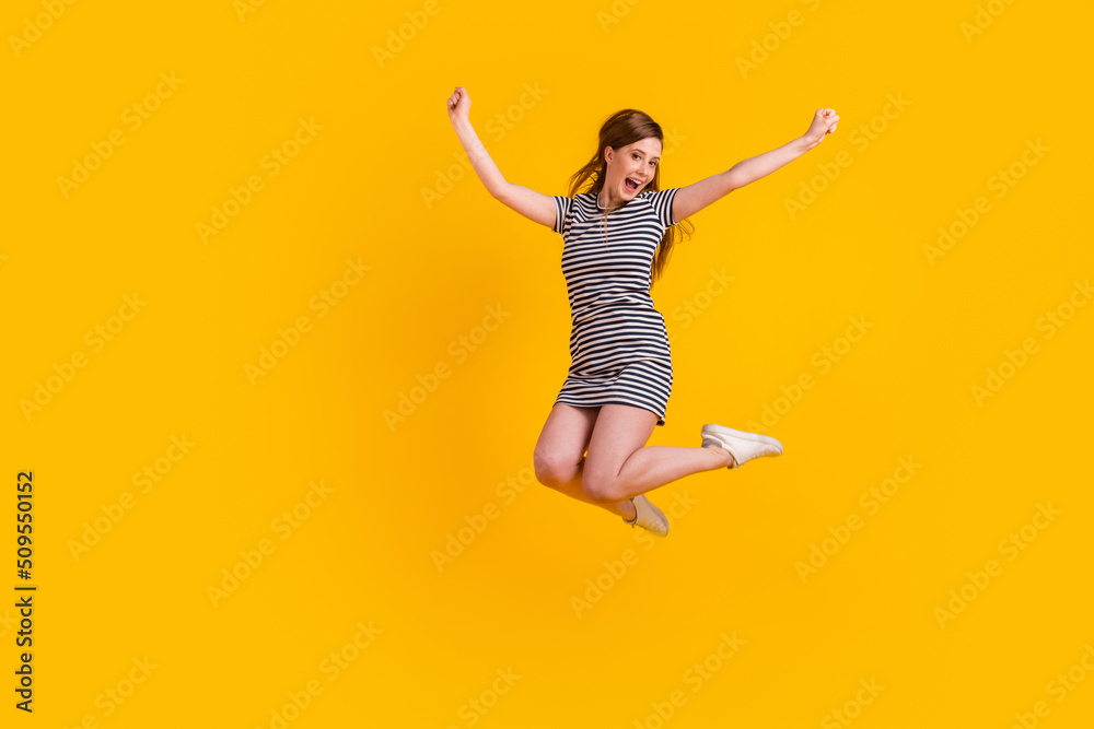 Full length photo of young excited girl jump up celebrate luck awesome champion isolated over yellow color background