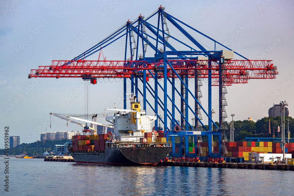 Logistics and transportation of container cargo ship with working crane bridge in shipyard, logistic import export and transport industry background, seaport with reduced amount of goods.