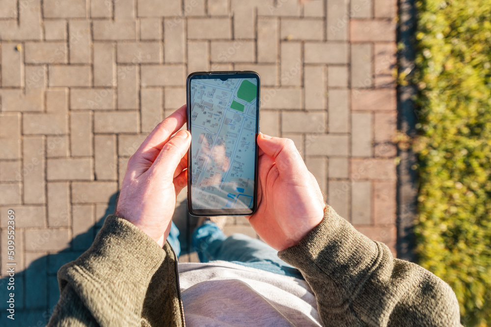 Man holds a smartphone with online maps application. Close-up, top view.  The concept of Internet applications for navigation and GPS Stock Photo |  Adobe Stock