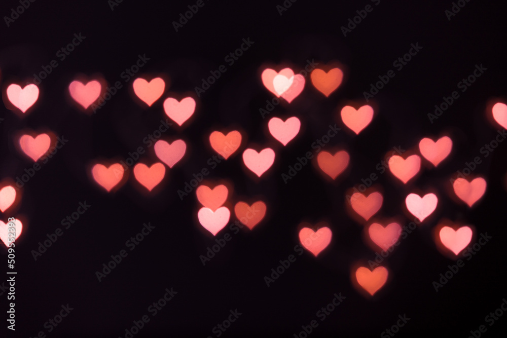soft defocused bokeh background with pink hearts, light from garland with open camera aperture, valentine's day background