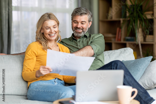 Family Insurance Concept. Happy Middle Aged Couple Reading Documents At Home © Prostock-studio