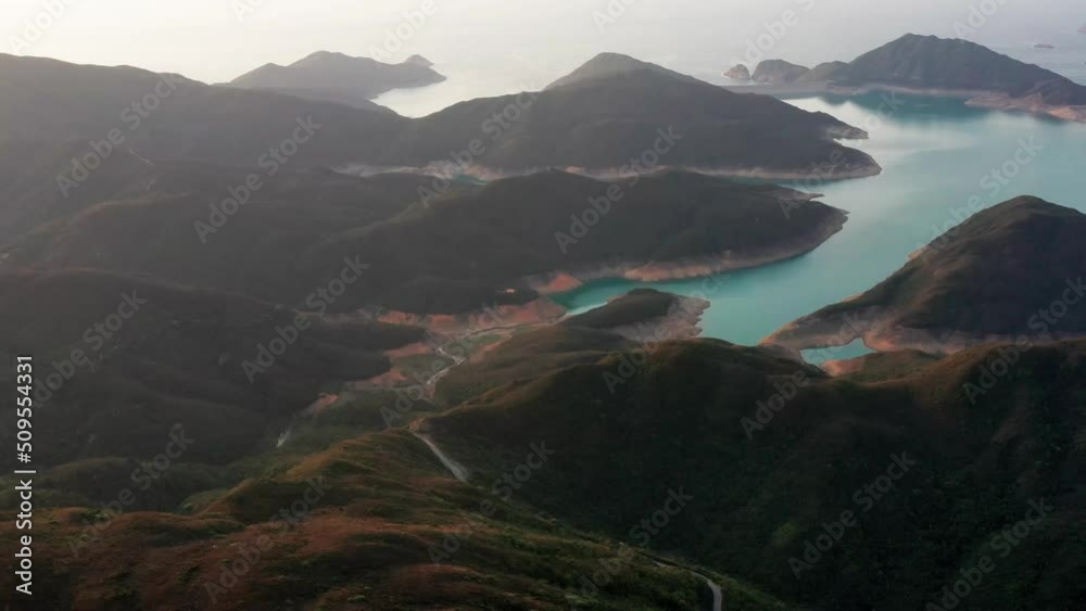 Aerial cinematic shot of High Island Reservoir East Dam in Sai Kung Hong Kong.  It is a rare volcanic hexagonal rock columns, beaches and islands, geological formations, sea bay.
