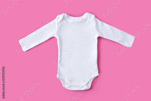 White baby clothes on pink backgfround. Copy space