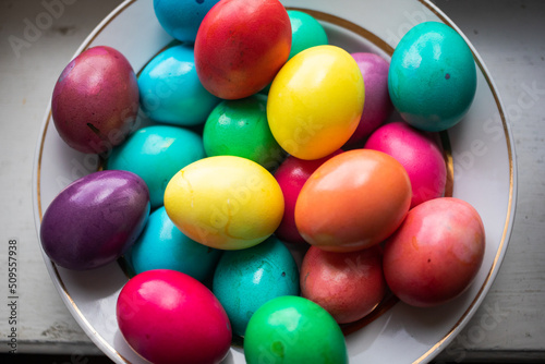 Papier peint painted multi-colored chicken eggs in a wide white plate as a symbol of the holi