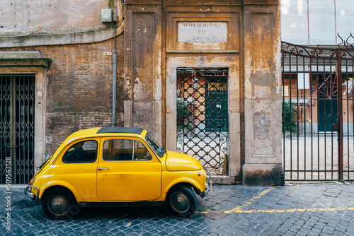 a classic fiat 500 vehicle is parked in roman street photo