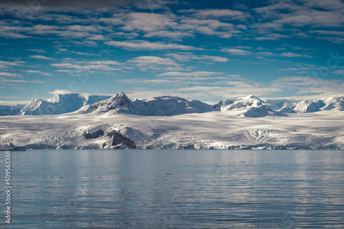 Antarctica mountains and sea. Clouds and blue sky