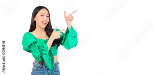 Attractive beautiful positive happy smile asian woman hands point up and pose with empty space wearing green shirt and jeans.