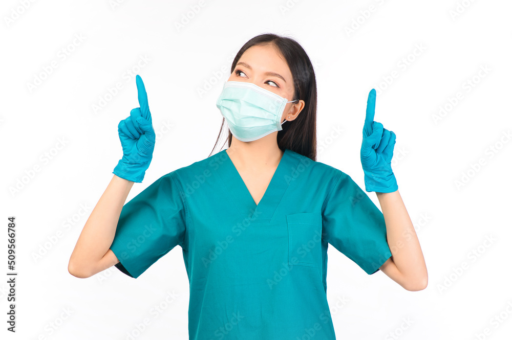 portrait asian female doctor in scrubs standing pointing fingers protection flu cold facial mask white background copy space for your advertisement, Self-isolation, social distancing. portrait asian female doctor in scrubs standing pointing fingers protection flu cold facial mask white background copy space for your advertisement, Self-isolation, social distancing.