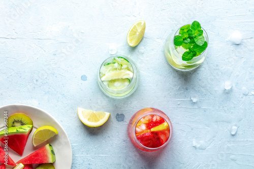 Summer cocktails. Cold drinks with fresh fruits. Healthy mocktails. Citrus, strawberry and cucumber lemonades, overhead flat lay shot with copy space