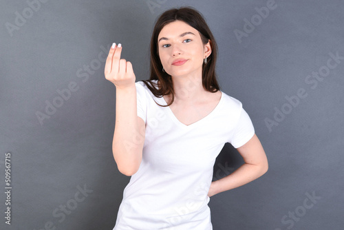 What the hell are you talking about. Shot of frustrated young beautiful Caucasian woman we gesturing with raised hand doing Italian gesture, frowning, being displeased and confused with dumb question.