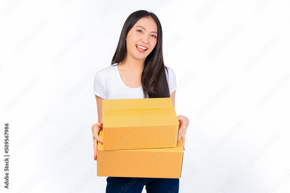 Happy cute asian woman smiling and holding package online marketing and delivery Start a small business at home on white background, Delivery shipping service concept. Happy cute asian woman smiling and holding package online marketing and delivery Start a small business at home on white background, Delivery shipping service concept.