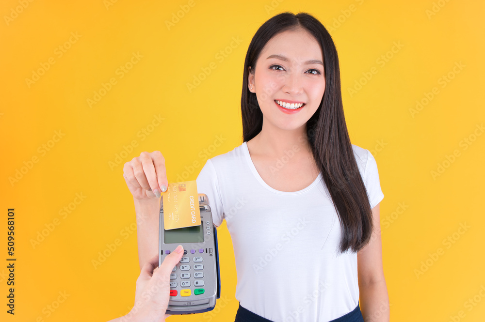 Moment of payment, payment with a credit card through terminal money yellow background,Mobile banking, online shopping Payment by card with the payment terminal. Moment of payment, payment with a credit card through terminal money yellow background,Mobile banking, online shopping Payment by card with the payment terminal.