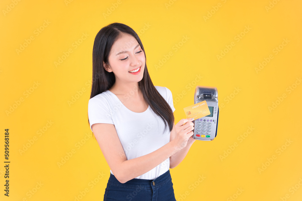 Moment of payment, payment with a credit card through terminal money yellow background,Mobile banking, online shopping Payment by card with the payment terminal. Moment of payment, payment with a credit card through terminal money yellow background,Mobile banking, online shopping Payment by card with the payment terminal.
