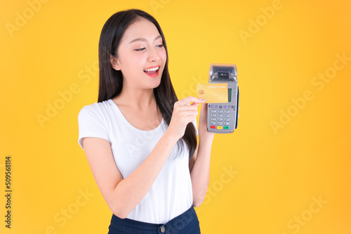 Moment of payment, payment with a credit card through terminal money yellow background,Mobile banking, online shopping Payment by card with the payment terminal.