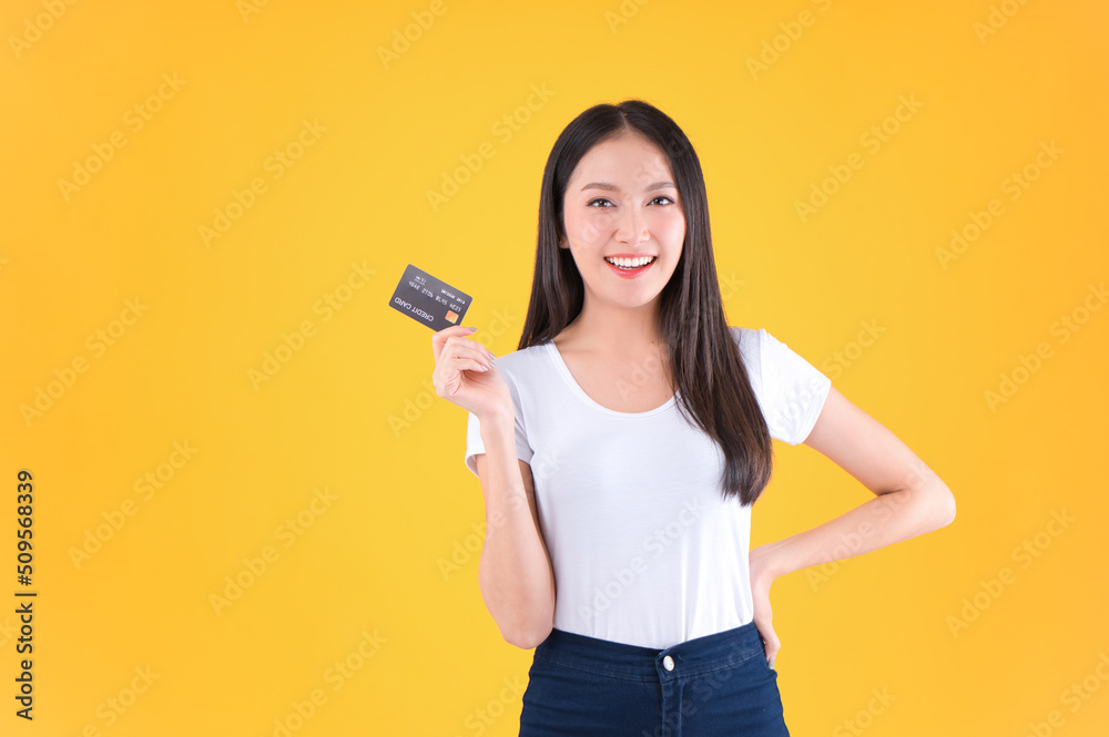 Photo happy positive pretty asian woman smile showing, presenting credit card for payment or paying online business payment credit card for confident money and financial concepts yellow background. Photo happy positive pretty asian woman smile showing, presenting credit card for payment or paying online business payment credit card for confident money and financial concepts yellow background.