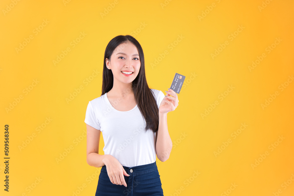 Photo happy positive pretty asian woman smile showing, presenting credit card for payment or paying online business payment credit card for confident money and financial concepts yellow background. Photo happy positive pretty asian woman smile showing, presenting credit card for payment or paying online business payment credit card for confident money and financial concepts yellow background.