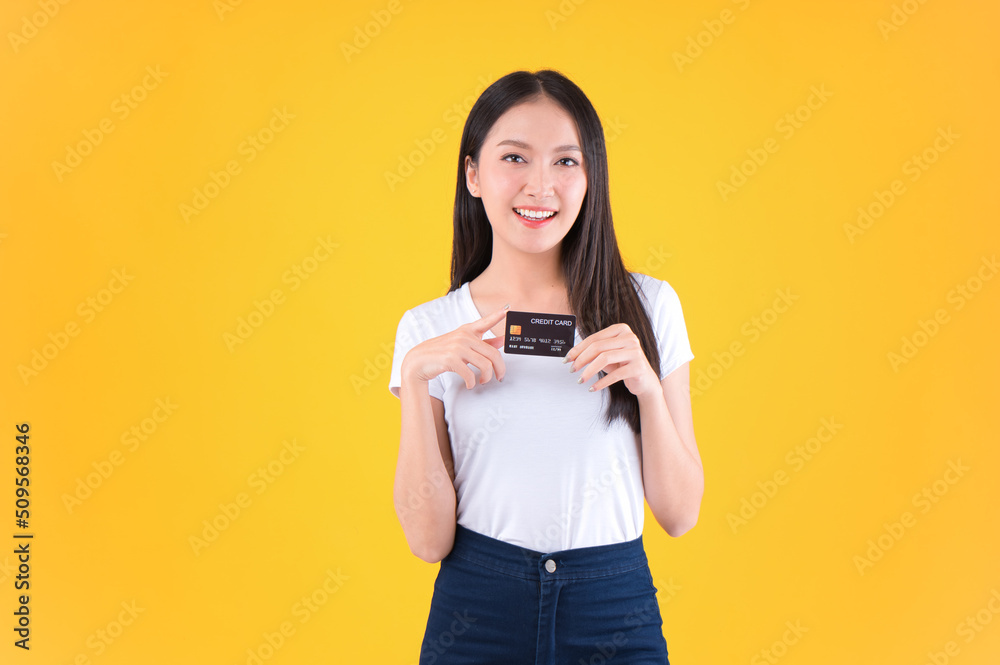 Photo happy positive pretty asian woman smile showing, presenting credit card for payment or paying online business payment credit card for confident money and financial concepts yellow background. Photo happy positive pretty asian woman smile showing, presenting credit card for payment or paying online business payment credit card for confident money and financial concepts yellow background.