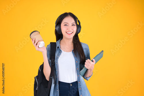 Portrait Cheerful young asian female student with backpack holding books education back to school and lifestyle concept yellow background.